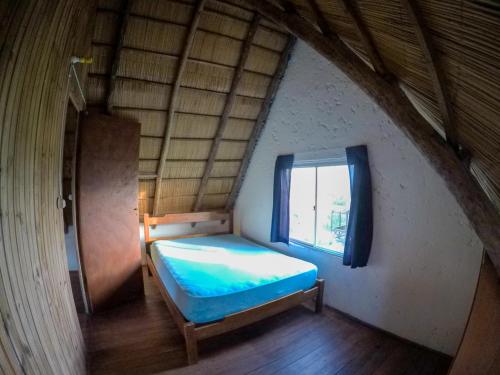 プンタ・デル・ディアブロにあるComplejo Diablo Verde Punta del Diabloのベッドと窓のある小さな寝室