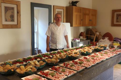 a man standing in front of a buffet of food at The Old Flax Mill Yoga Retreat in Coleraine