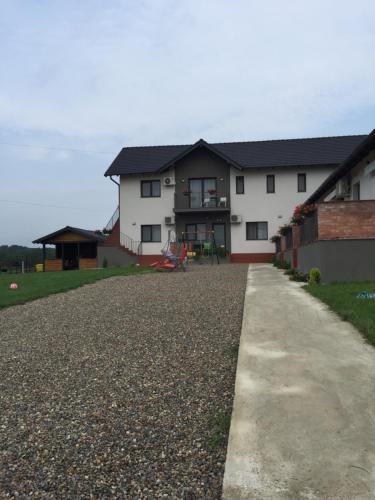 a house with a gravel driveway in front of it at Pensiunea Gloria in Baile Felix