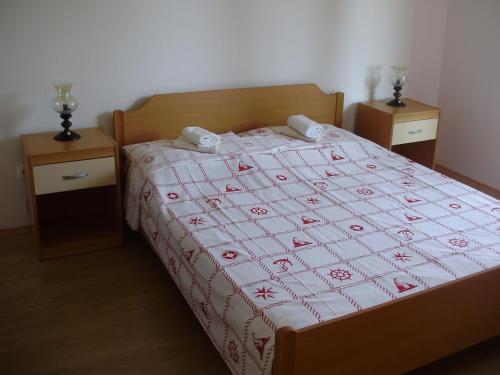 a bedroom with a bed with a red and white quilt at Villa Welcome in Vrboska