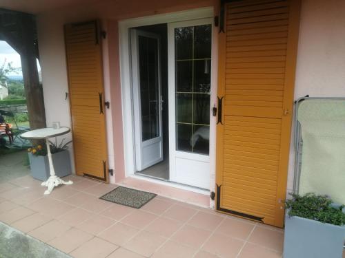 una puerta delantera de una casa con puertas amarillas en Le petit nid, en Égletons