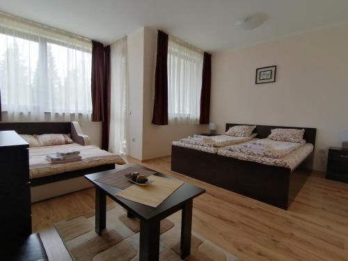 a living room with two beds and a table at Borovets Gardens Studio D36 in Borovets
