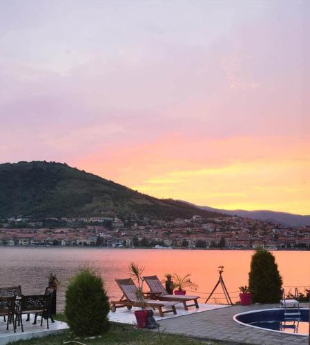a sunset over a body of water with tables and chairs at CHALET Orsova in Orşova