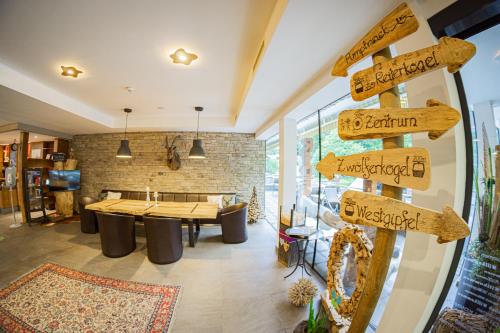 a directional sign in a room with a table at Hotel ALPINA in Saalbach-Hinterglemm