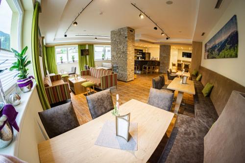 an open living room with a table and chairs at Hotel ALPINA in Saalbach Hinterglemm