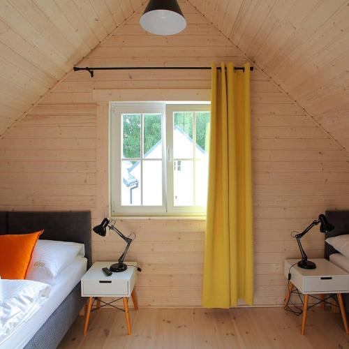 a bedroom with a bed and two lamps on tables at RODZINKA B&M Całoroczne domki w stylu skandynawskim , podgrzewany basen z mobilnym zadaszeniem in Niechorze