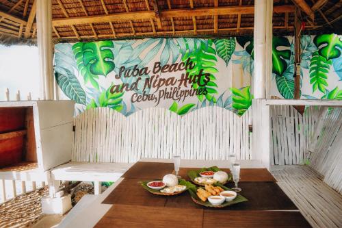 una mesa con dos platos de comida. en Suba Beach Nipa Huts en Daanbantayan