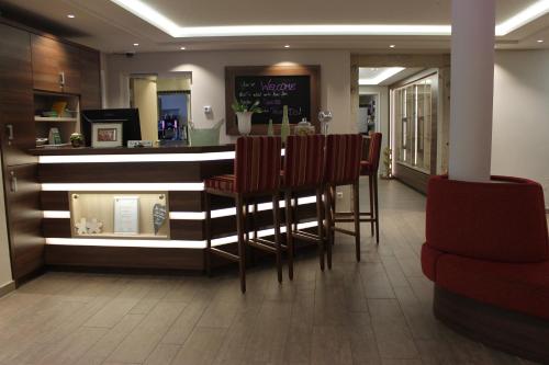 a bar in a restaurant with chairs and a counter at Hotel Number One in Waidhaus