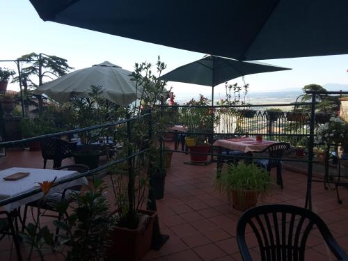 een patio met tafels, stoelen en parasols bij Casa Kita in Cortona