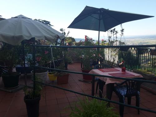 a patio with a table and an umbrella at Casa Kita in Cortona