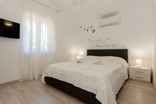 a white bedroom with a bed with a white blanket at Villa Rose in Kršan