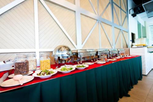 a long table with plates of food on it at Ramaburin Resort Patong - SHA Extra Plus in Patong Beach