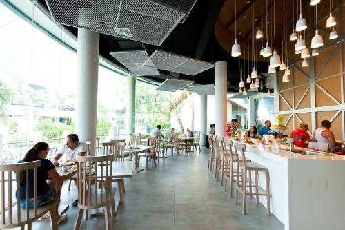 a restaurant with people sitting at tables and a bar at Ramaburin Resort Patong - SHA Extra Plus in Patong Beach