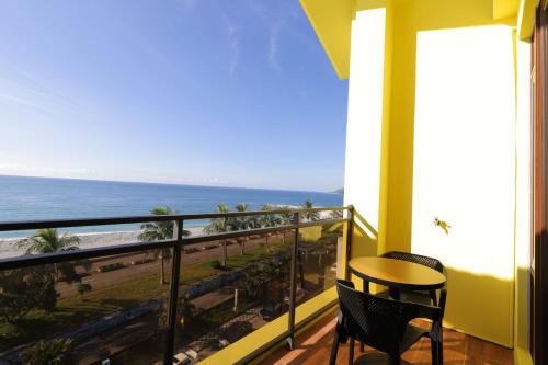 a balcony with a table and chairs and the ocean at 花蓮諾丁漢海景民宿 Nottingham Seaview Inn in Hualien City