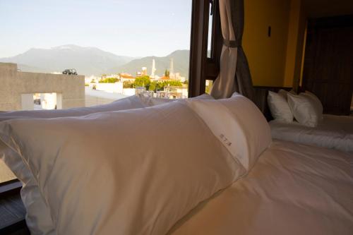 a bed with white sheets in a room with a window at 花蓮諾丁漢海景民宿 Nottingham Seaview Inn in Hualien City