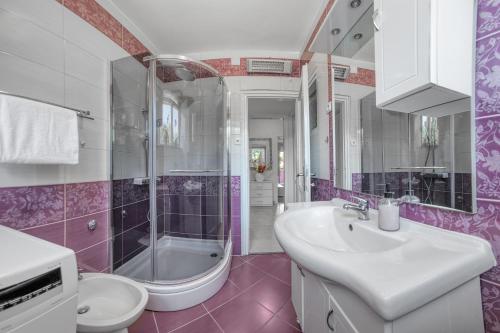 a bathroom with a sink and a shower and a toilet at M & M Apartment in Pula