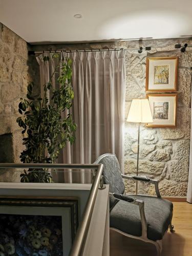 a living room with a chair and a lamp at Isabel do Couto - casa de charme in Castro Daire
