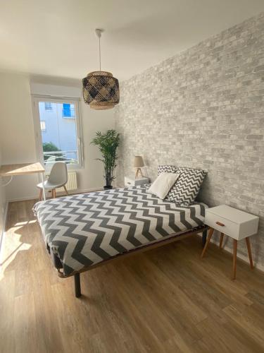- une chambre avec un lit et un mur en briques dans l'établissement Le Travel, à Acigné