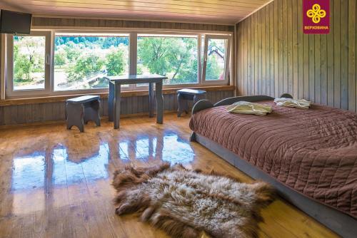 a bedroom with a bed and a rug on the floor at Villa «Zlata» in Verkhovyna