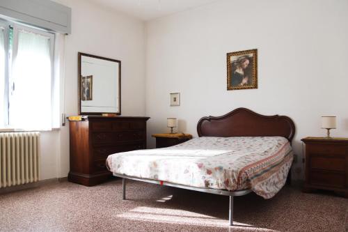 een slaapkamer met een bed, een dressoir en een spiegel bij Cimarosa 5 in Follonica