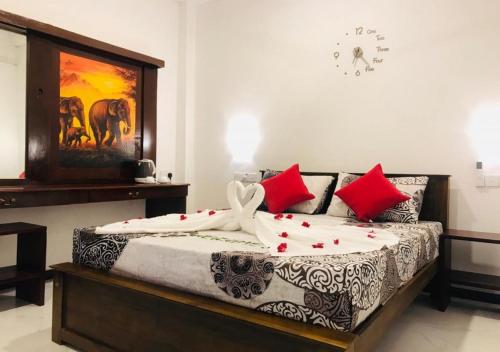 sypialnia z łóżkiem z białymi i czerwonymi poduszkami w obiekcie Inn Sea Horizon Ahungalla w mieście Ahungalla