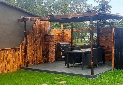 a wooden pergola with a table and chairs on a deck at Apart Oderblick in Neubleyen