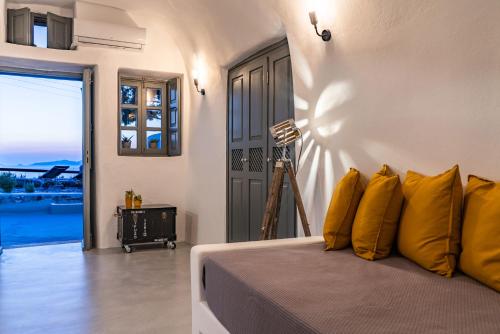 a bedroom with a bed with yellow pillows at Noelia Suites in Oia