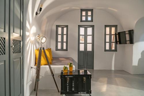 a room with a bed and a table with a lamp at Noelia Suites in Oia