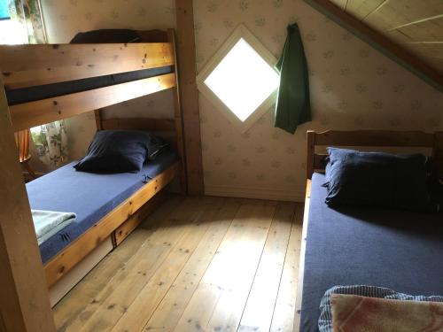 a bedroom with two bunk beds and a window at Vandrarhem Svänö in Hillerstorp