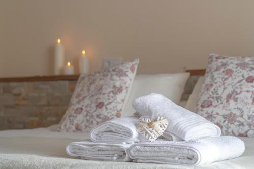 a pile of towels on a bed with two pillows at Casa Rural El Morral in La Mata de los Olmos