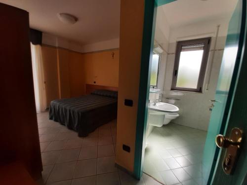 a bathroom with a bed and a sink and a toilet at Hotel Pegaso in San Giovanni Rotondo