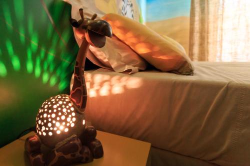 una estatua de una jirafa sentada en una cama en Mini Hotel en Rímini