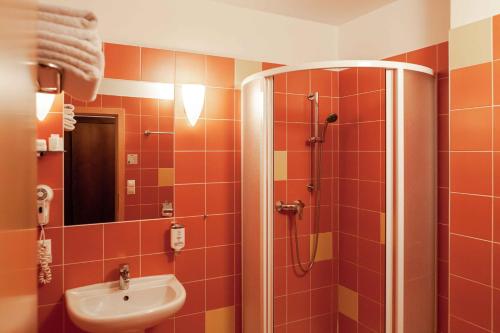 a bathroom with a shower and a sink at Equitana Hotel Resort in Březnice