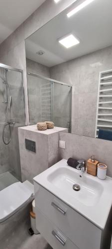 a white bathroom with a sink and a shower at BOHO MARE Apartament Pobierowo in Pobierowo