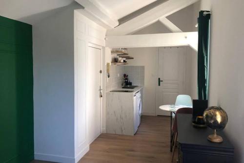 une chambre avec une cuisine avec une table et une chambre avec une cuisine dans l'établissement Studio sous les toits, à Lyon