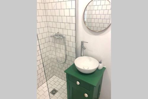 a bathroom with a green sink and a shower at Studio sous les toits in Lyon