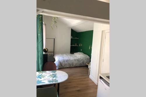 a bedroom with a bed and a table in a room at Studio sous les toits in Lyon