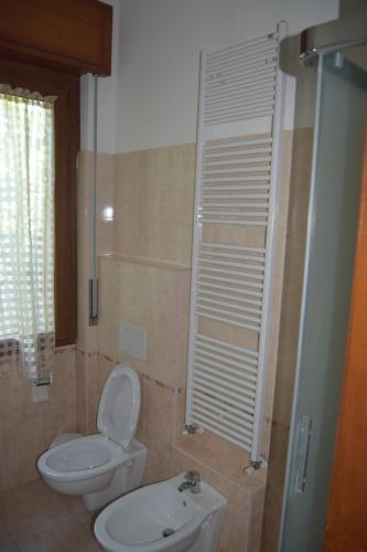 布斯托阿西齊奧的住宿－Al Salice tranquillità nel verde Via Amendola 24，浴室配有白色卫生间和盥洗盆。