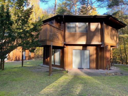 a tree house with a deck and a garage at Hotel Residenz WALDOASE in Ahlbeck