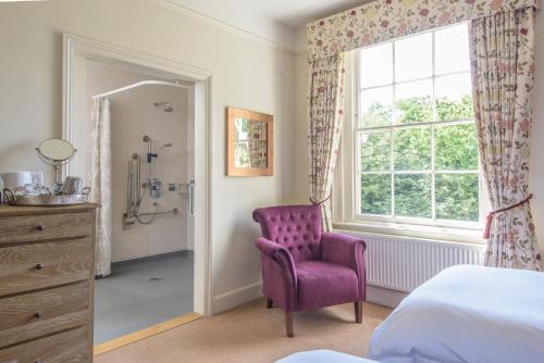 a bedroom with a purple chair and a window at Sissinghurst Castle Farmhouse in Sissinghurst