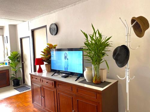 a tv on a wooden cabinet in a living room at Cozy family room At 103 condominium 2 on nimman 12 in Chiang Mai