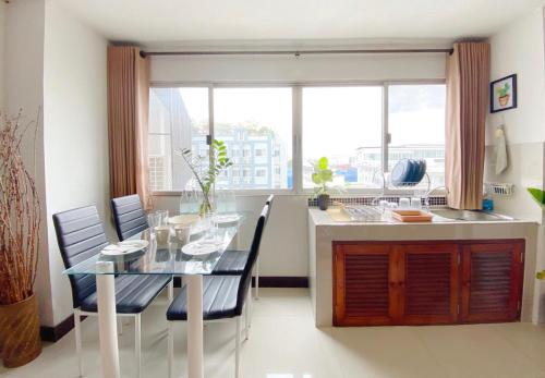 a kitchen and dining room with a glass table and chairs at Cozy family room At 103 condominium 2 on nimman 12 in Chiang Mai