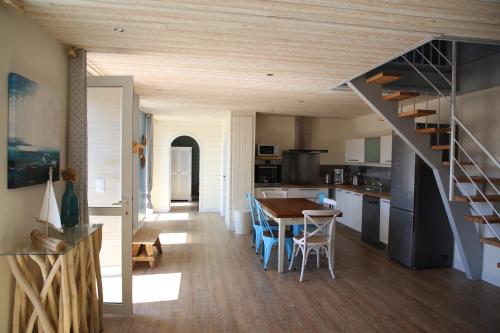 une cuisine et une salle à manger avec une table et un escalier dans l'établissement Ker Karreg (La Maison du Rocher), à Penmarcʼh