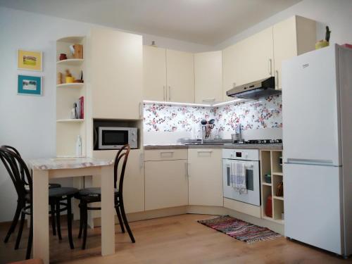 a kitchen with a table and a white refrigerator at Slávik Apartment in Dunajská Streda