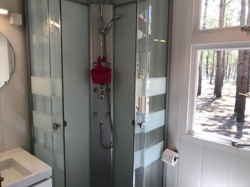 a bathroom with a shower and a sink and a window at Odeceixe Bungalow-Parque de Campismo Sao Miguel in Odeceixe