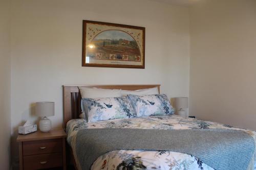 sypialnia z łóżkiem i zdjęciem na ścianie w obiekcie Victoria Cottage w mieście Robe