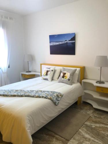 sypialnia z dużym łóżkiem z białą pościelą i poduszkami w obiekcie Lujan 3C entre cielo y mar w mieście Puntallana
