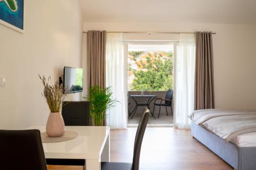 a living room with a bed and a table and a room at Korkyra Fit suites -free gym in Korčula