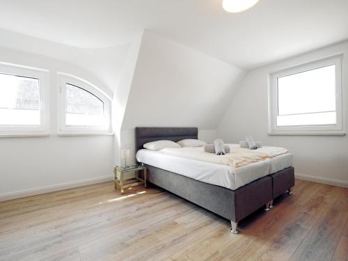 ein Schlafzimmer mit einem großen Bett und zwei Fenstern in der Unterkunft Ferienwohnungen am Reiterhof Sallenthin in Neu Sallenthin