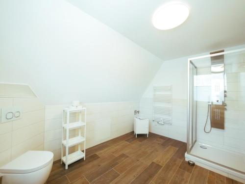 ein weißes Bad mit einem WC und einer Dusche in der Unterkunft Ferienwohnungen am Reiterhof Sallenthin in Neu Sallenthin